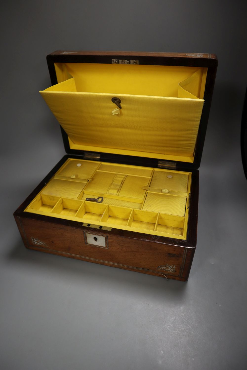 A Victorian ivory inlaid rosewood sewing box, width 30cm depth 22cm height 13cm, and a late Victorian red leather cased travelling toil